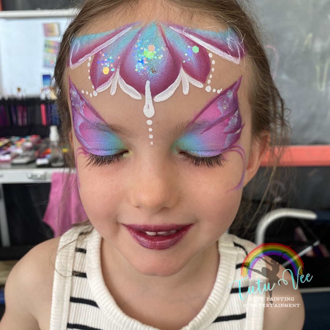 Blue butterfly face paint on a girl
